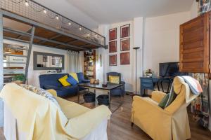 a living room with yellow chairs and a blue couch at Estudio La Cochera in Deltebre