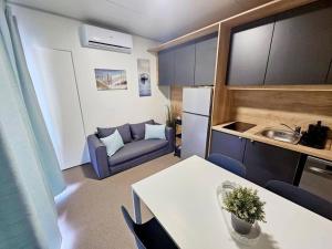 a small apartment with a table and a couch at Mobile home Sunset, Privlaka in Privlaka