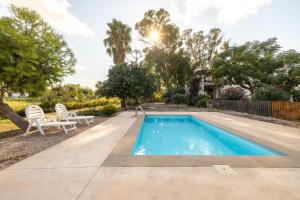a swimming pool in a yard with two chairs and a table at Estudio La Cochera in Deltebre