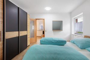 a bedroom with two beds and a flat screen tv at Ferienwohnung Weinbergblick in Auggen