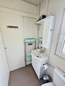 a white bathroom with a sink and a toilet at Mobile home Sunset, Privlaka in Privlaka