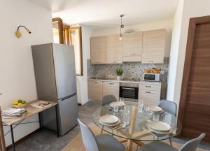a kitchen with a glass table and a refrigerator at a casa di ASIA in Dalmine
