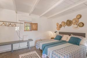 a bedroom with two beds and a table and a window at Can Vicent in Illes Balears