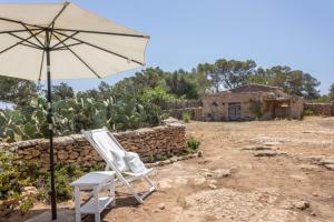 a chair and an umbrella in front of a house at Can Vicent in Illes Balears