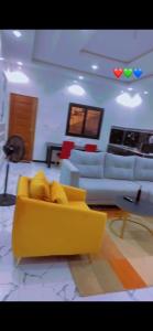 a living room with a yellow couch and couches at Relaxe casa in Thiès +6 photos