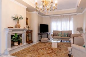 a living room with a couch and a fireplace at Villa Candelaria Sol y Piscina in Bormujos
