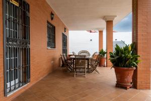 a patio with a table and chairs on a brick wall at Villa Candelaria Sol y Piscina in Bormujos