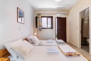 a white bedroom with a large bed with towels on it at Studio Aias in Póndi