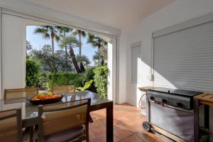 a kitchen with a dining table and a window at Frontline paradise townhouse in Estepona