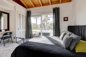 a bedroom with a bed with a window and a desk at Frontline paradise townhouse in Estepona +18 photos
