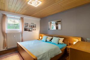 a bedroom with a bed and a desk and a window at Ferienwohnung Kühlmeyer in Bundenthal