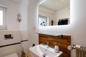 a bathroom with a sink and a mirror at Ferienwohnung Kühlmeyer in Bundenthal +28 photos