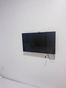 a flat screen tv hanging on a white wall at Pousada Descanso Do Preguiça in Barreirinhas +23 photos