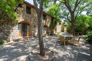 a table and chairs in front of a stone house at Serra de Prades in Montblanc