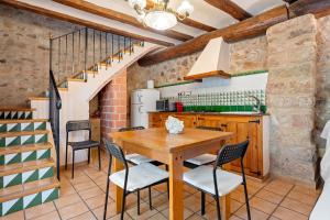 a kitchen with a wooden table and chairs at Serra de Prades in Montblanc