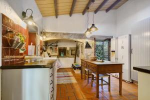 a large kitchen with a table and a counter top at Serreta Island Home in Serreta