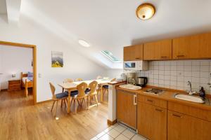 a kitchen and dining room with a table and chairs at Fewo Brünnstein - Nr 60 Pool, Sauna in Oberaudorf