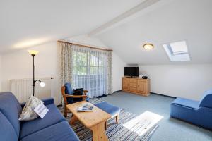 a living room with a blue couch and a table at Fewo Brünnstein - Nr 60 Pool, Sauna in Oberaudorf