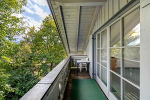 a balcony of a house with a green rug at Fewo Brünnstein - Nr 60 Pool, Sauna in Oberaudorf