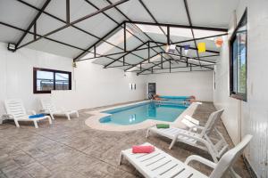 a indoor pool with chairs and a pool table at Villa Pastrana in Chipiona