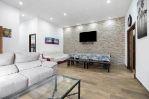 a living room with a white couch and a tv at Villa Pastrana in Chipiona
