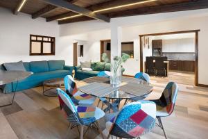 a living room with a blue couch and a table and chairs at Casa Miranda 1 in Candelaria