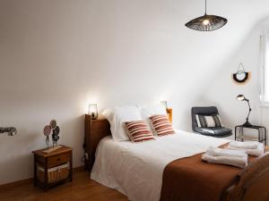 a bedroom with a bed with white sheets and pillows at L'escale Kénanaise in Saint-Quay-Perros