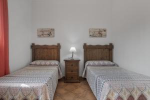 a room with two beds and a table with a lamp at Casa Carmelo 1 familas o parejas in Conil de la Frontera +17 photos