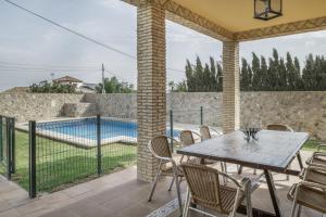 a patio with a table and chairs and a swimming pool at Casa Carmelo 1 familas o parejas in Conil de la Frontera