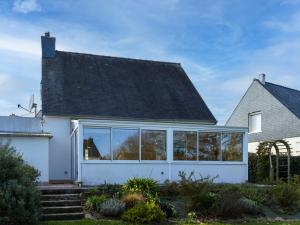a white house with a black roof at L'escale Kénanaise in Saint-Quay-Perros