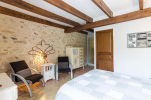 a bedroom with a bed and two chairs in a room at Chambre Chardon, Escapade Nature in Auriac-du-Périgord