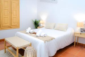 a bedroom with a white bed with a table and a chair at El Riu del Cel in Lloret de Mar