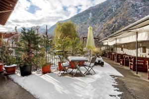 a patio with a table and chairs in the snow at Agriturismo Quinto Quarto in Grosio