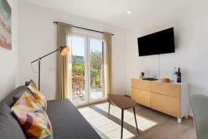 a living room with a couch and a tv at Drop In Beach Apartments in Lourinhã