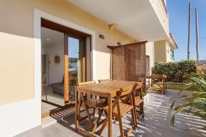 a wooden table and chairs on the balcony of a house at Drop In Beach Apartments in Lourinhã