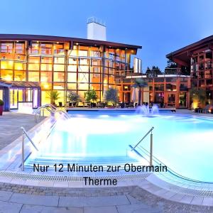 a large swimming pool in front of a building at Angie's Ferienapartment in Lichtenfels