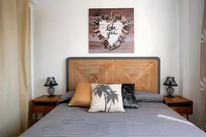 a bedroom with a bed with a wooden headboard and two lamps at Atico Playa Gandia in Playa de Gandia +26 photos