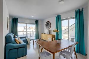 a living room with a blue couch and a table at Atico Playa Gandia in Playa de Gandia