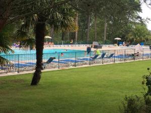 a large swimming pool with people in a park at Charmant Appartement - Bordaberry in Urrugne