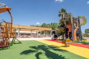 a park with a playground with a slide at Mh sympa au camping domaine la yole in Vendres