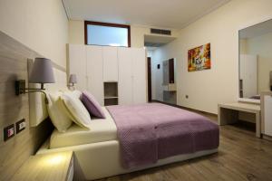 a bedroom with a large bed and a window at Hotel VD Roleks in Vlorë