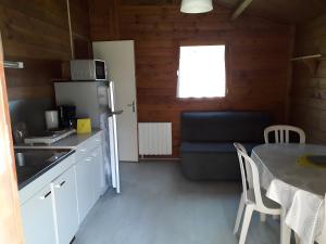 a kitchen and dining room with a table and a refrigerator at Chalet bois 7 Domaine Les Epinettes in Saint-Gervais