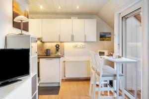 a kitchen with white cabinets and a table and chairs at Meeresfeeling in Horumersiel in Horumersiel