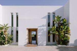 a white house with a door and plants at Villa 10 9 in Sant Josep