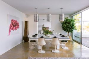 a white dining room with a table and chairs at Villa 10 9 in Sant Josep