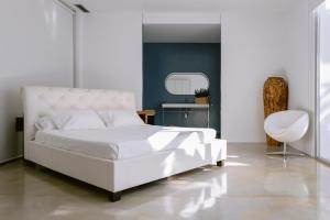 a bedroom with a white bed and a white chair at Villa 10 9 in Sant Josep