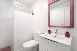 a white bathroom with a toilet and a sink at Terrazas de doñana b91a in Sanlúcar de Barrameda +21 photos