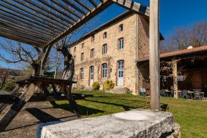 a picnic table in front of a brick building at Cabane Ecolodge La Chastanha in Saint-Symphorien-de-Mahun +12 photos