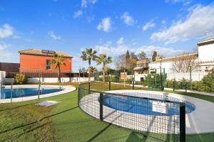 a tennis court with a net on a grass field at Terrazas de doñana b91a in Sanlúcar de Barrameda