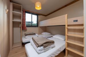 a bedroom with two bunk beds and a window at Chalet 35m2 - Molène in Plouhinec